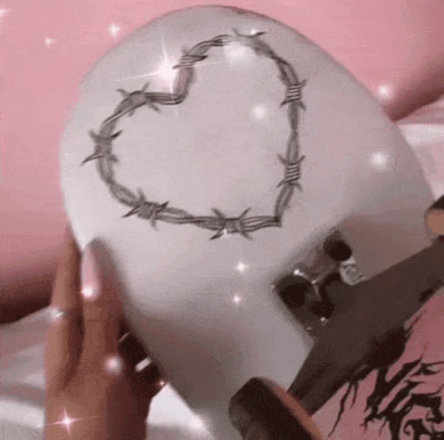 Person Holding Skateboard With Heart of Barbed Wire
