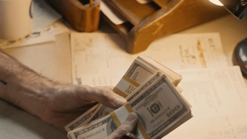 Person Holding Stack of 100 Dollar Bills
