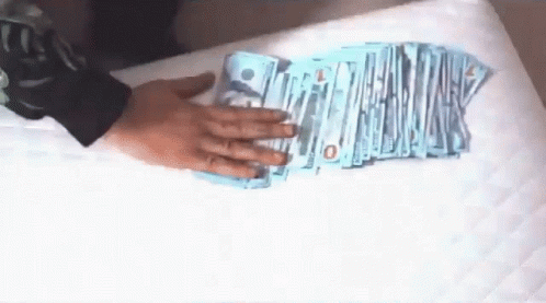 Person Holding Stack of Money With 10