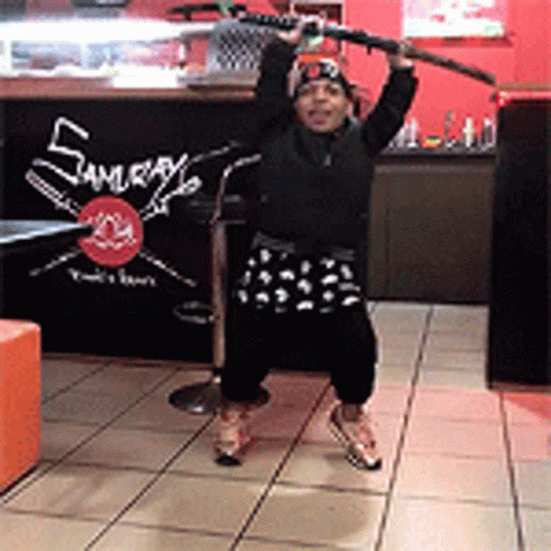 Person Holding Sword in Front of Samurai Sign
