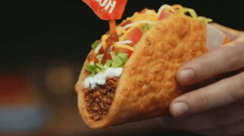 Person Holding Taco With Hot Sauce Packet