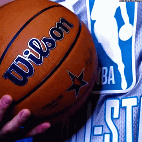 Person Holding Wilson Basketball in Front of NBA Logo