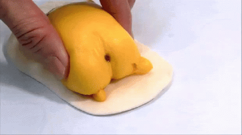 Person Holding Yellow Chicken Butt Object