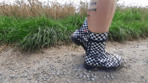 Person in Black-and-White Checkered Boots With Peace Tattoo