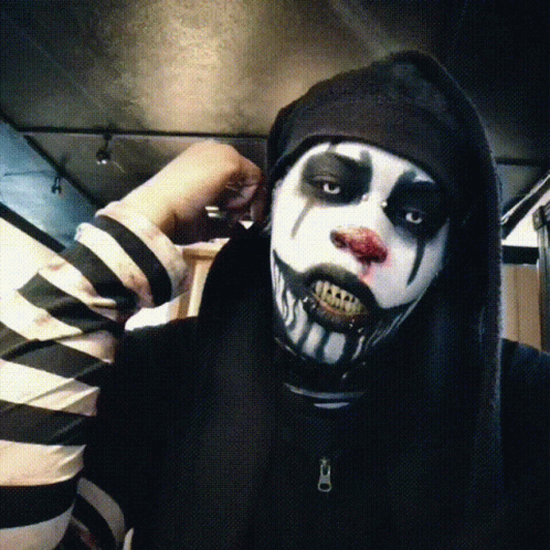 Person in Black and White Striped Shirt and Clown Makeup