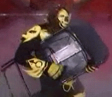 Person in Black and Yellow Costume Holding Black Object