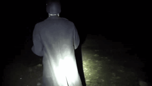 Person in Black Coat Standing in Dark