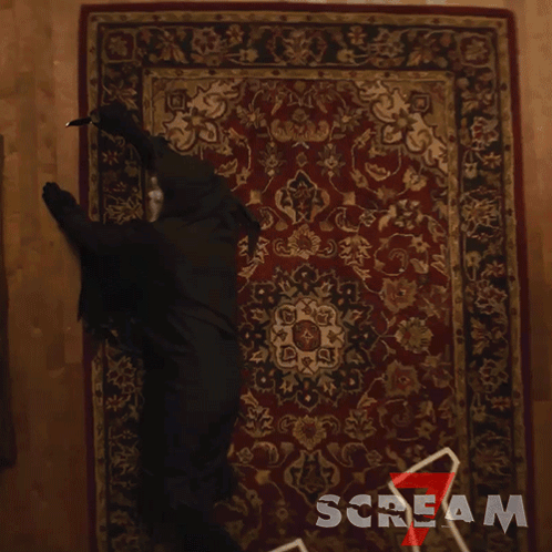 Person in Black Costume Crawling on Scream Rug