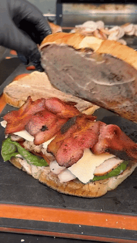 Person in Black Gloves Cutting Sandwich