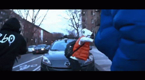 Person in Black Hoodie with 260 Standing in Front of Car