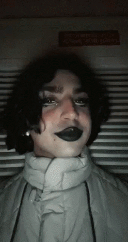 Person in Black Lipstick and White Jacket Looking at Camera