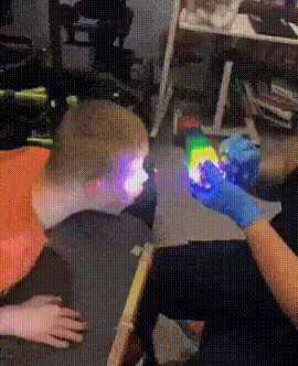Person in Blue Gloves Holding Rainbow Light