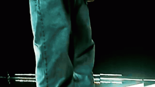 Person in Blue Jeans on Dark Surface