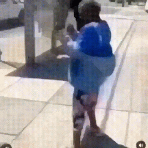 Person in Blue Shirt Walking Down Street