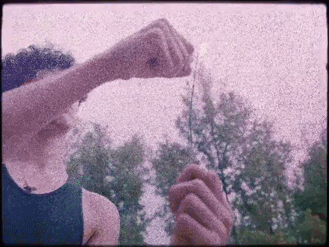 Person In Blue Tank Top Holding Item GIF