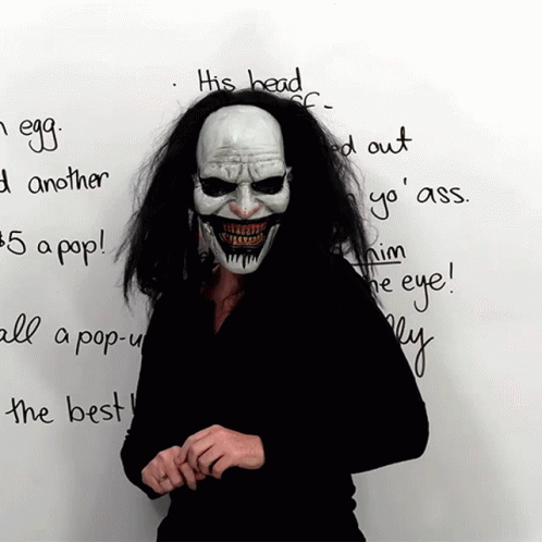 Person in Clown Mask Standing Before Whiteboard