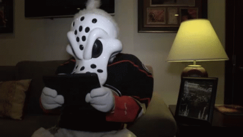 Person in Dalmatian Mask Using Tablet