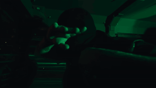 Person in Dark Room With Green Lights on Face