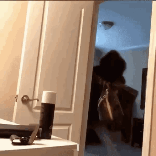 Person in Doorway with Deodorant Can on Table