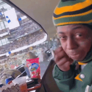 Person in Green and Yellow Striped Hat Eating Snack