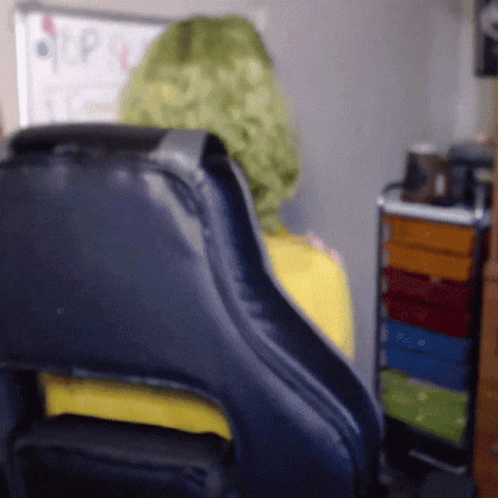 Person in Green Wig Sitting in Black Chair
