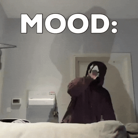Person in Hooded Jacket in Front of Mood Wall