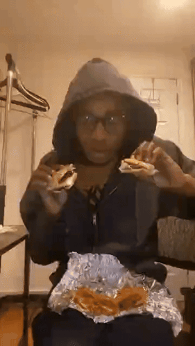Person in Hoodie Eating Sandwich
