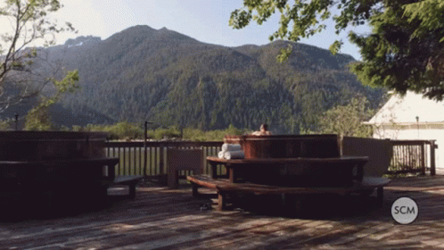 Person In Hot Tub With Mountains And SCM Logo GIF