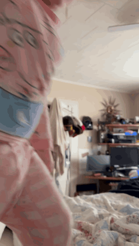 Person in Pink Pajamas Standing in Bedroom