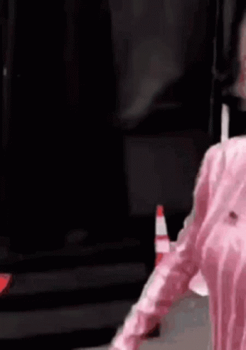 Person in Pink Shirt Next to Traffic Cone