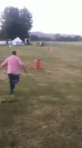 Person in Pink Shirt Running in Field
