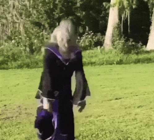 Person in Purple and Black Outfit in Grassy Field