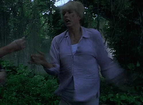 Person In Purple Shirt Standing In Green Forest GIF