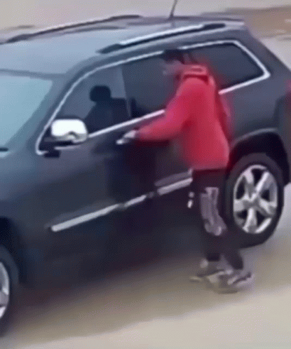 Person in Red Jacket Getting Out of Black SUV