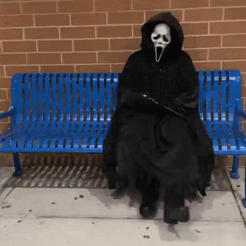 Person In Scream Costume Sitting On Blue Bench GIF
