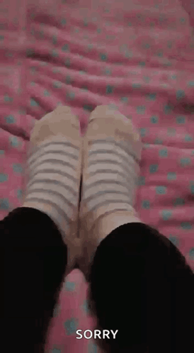Person in Striped Socks Lying on Bed Sorry