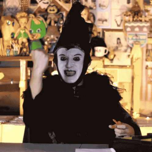 Person in Witch Costume Holding Pen