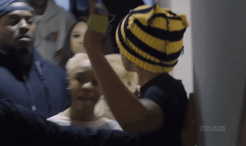 Person In Yellow And Black Striped Hat With Zeus GIF