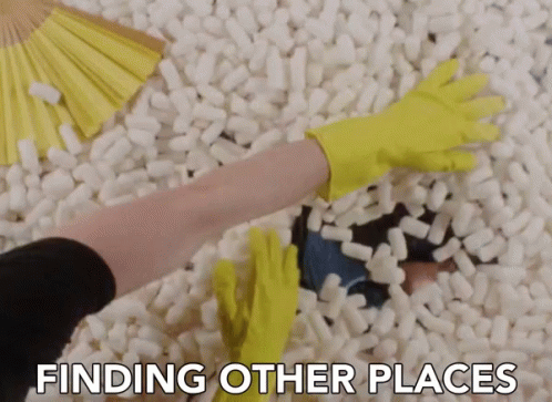 Person in Yellow Gloves Reaching Into Styrofoam Blocks