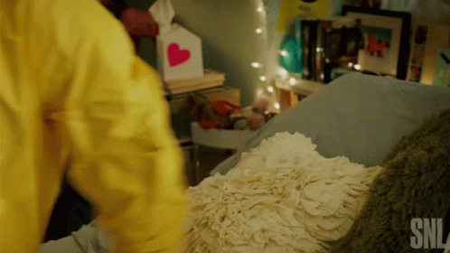 Person in Yellow Jacket Next to Bed