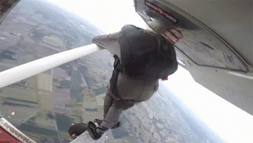 Person Jumping Out of Plane With Emergency Exit Sign