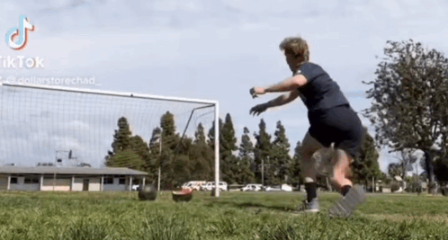 Person Kicking Soccer Ball in Front of Goal With TikTok