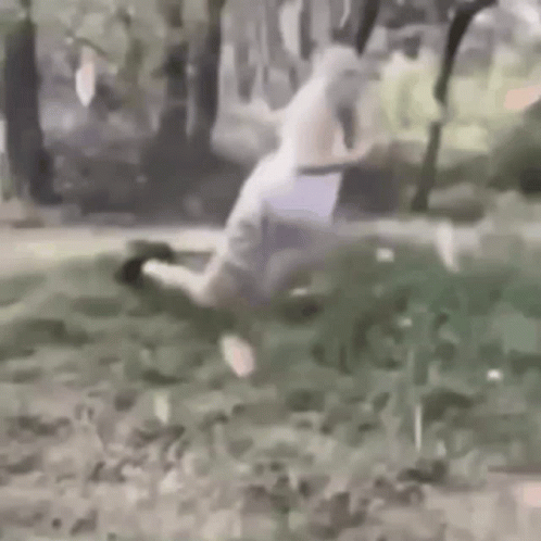 Person Kneeling in Grass with Knife