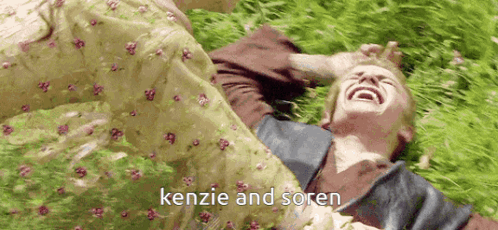 Person Laying In Grass With Kenzie And Soren GIF