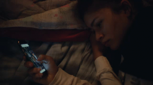 Person Laying on Bed Looking at Phone