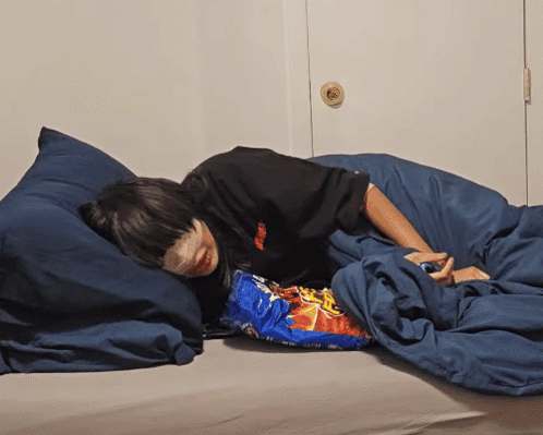 Person Laying on Bed With Doritos Bag