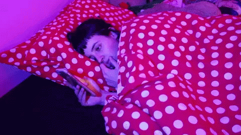 Person Laying on Bed with Polka Dot Blanket