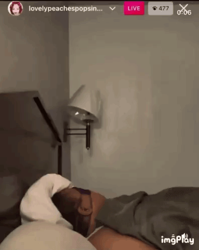 Person Laying on Bed With Wall Lamp