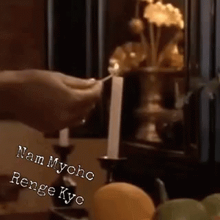 Person Lighting Candle in Dark Room
