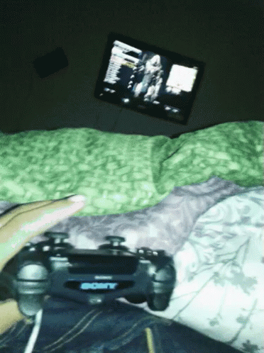 Person Lying on Bed Playing Video Game with Sony Controller